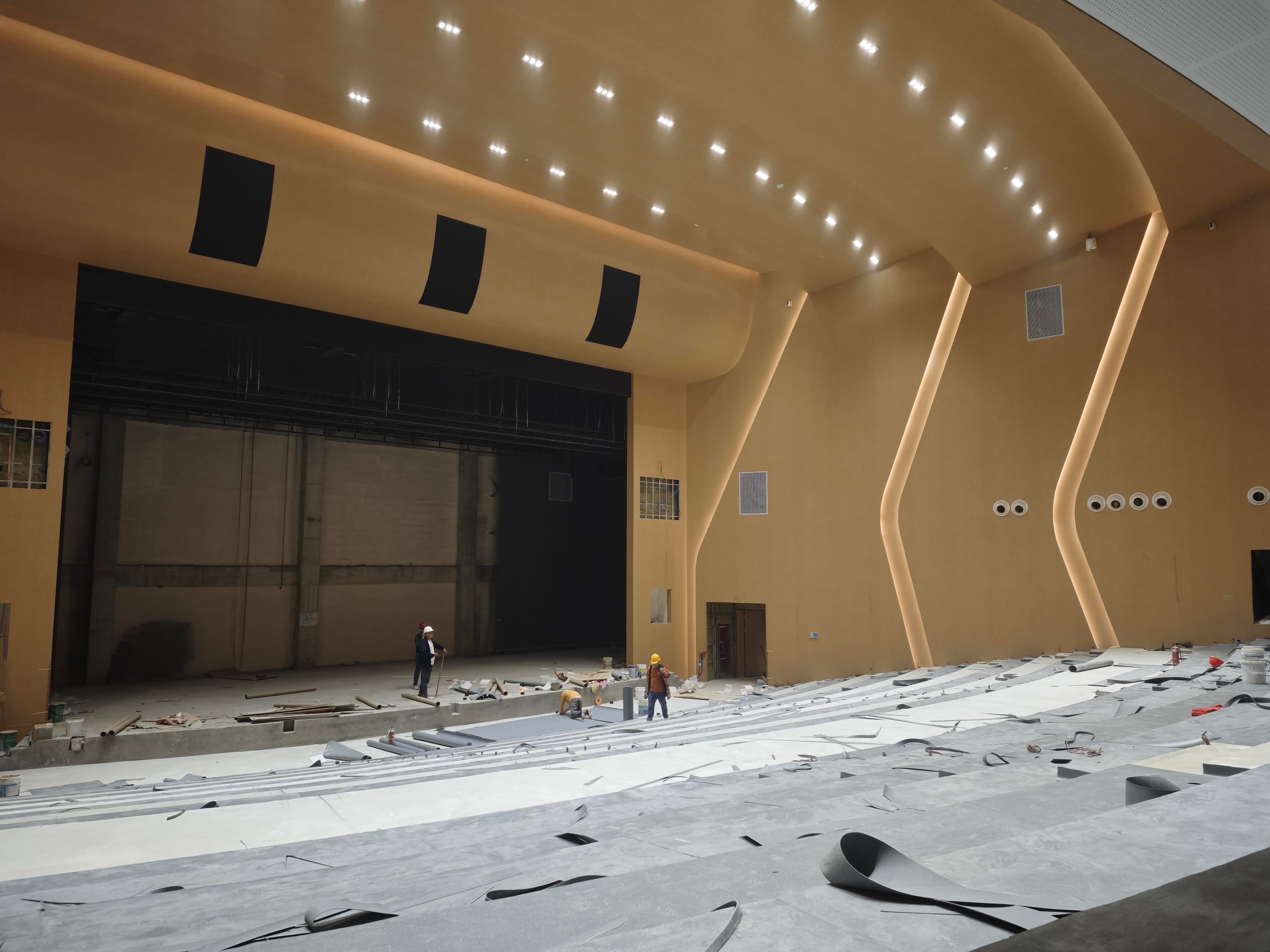Auditorium construction phase facing the stage opening with unfinished seating tiers