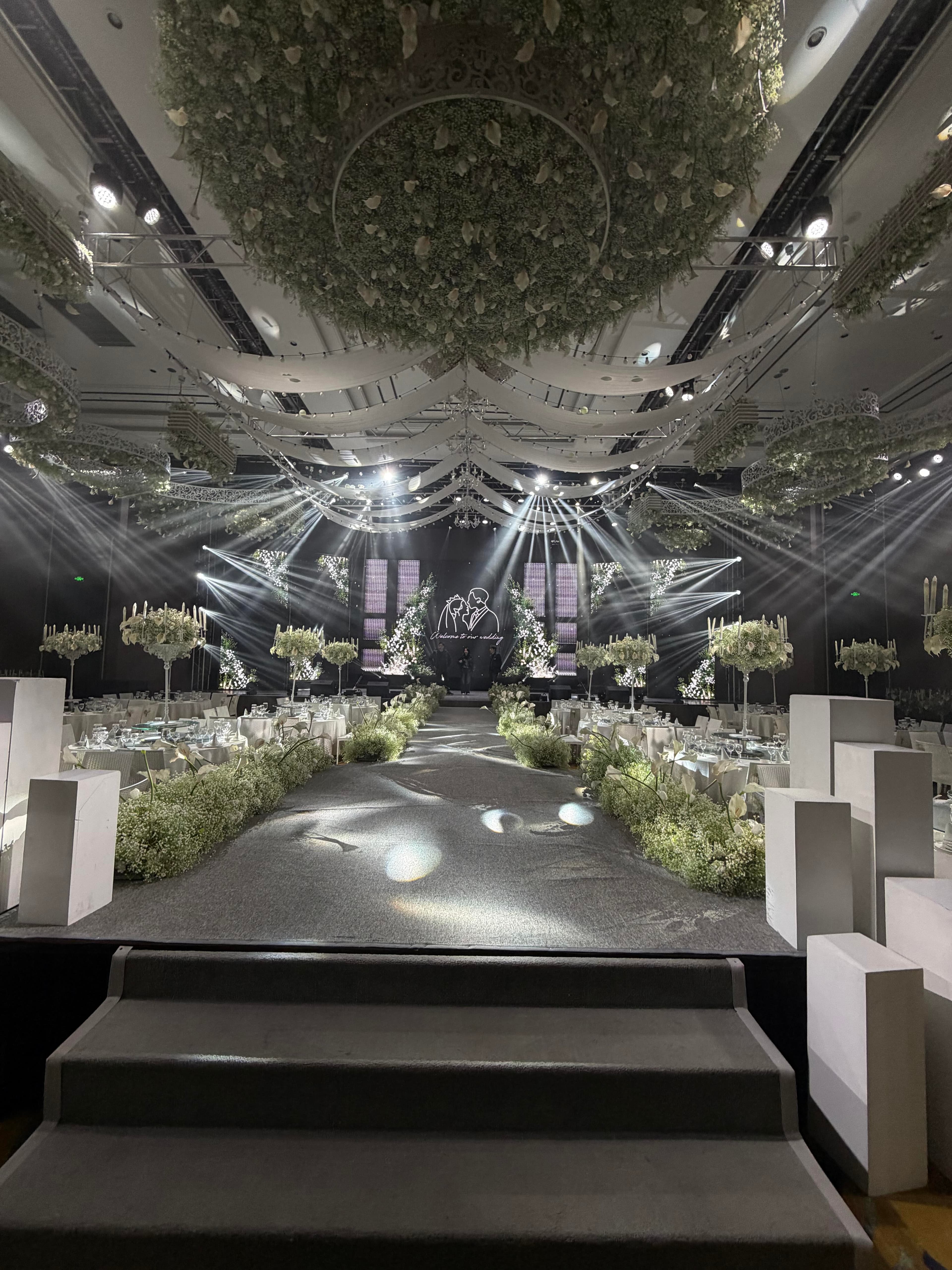 Minimalist pure white ballroom perspective with distributed linear lighting and stage LED anchors