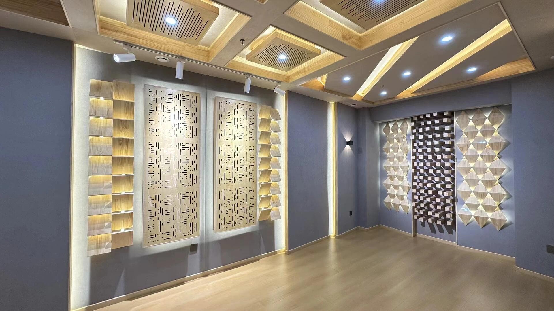 Empty recording room with gray acoustic fabric walls, wood flooring, ceiling absorbers, and illuminated diffuser arrays