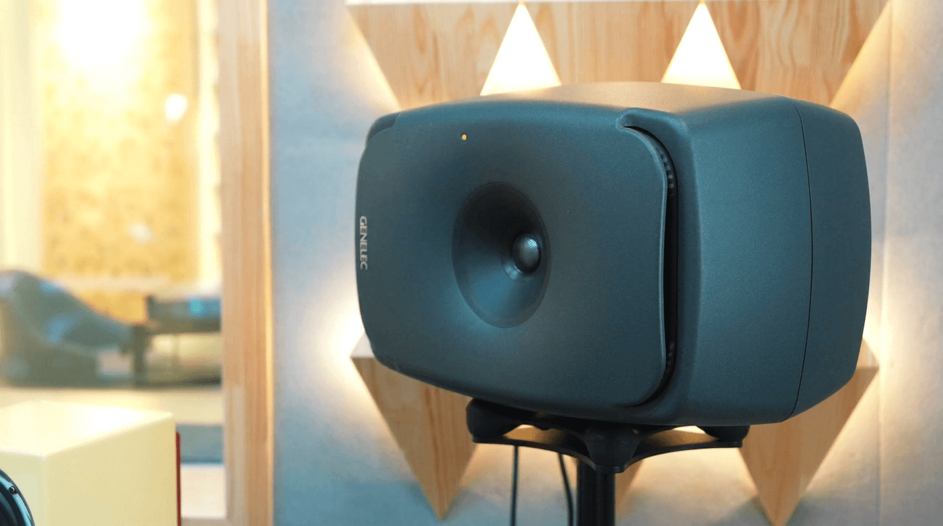 Close-up of Genelec coaxial active studio monitor in front of triangular wooden diffuser panels