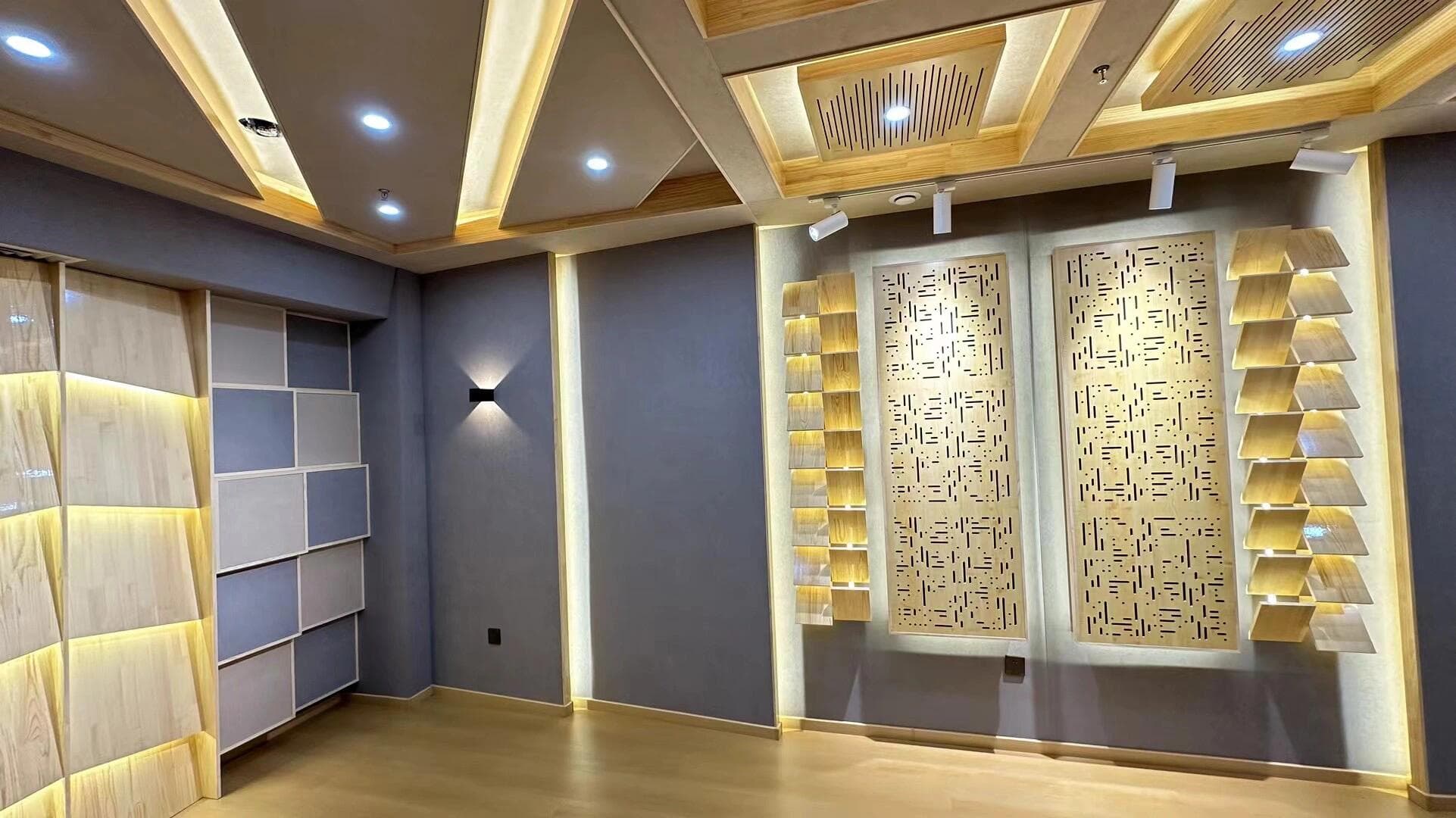 Recording room side wall with geometric diffuser modules, slotted acoustic panels, and concealed warm lighting