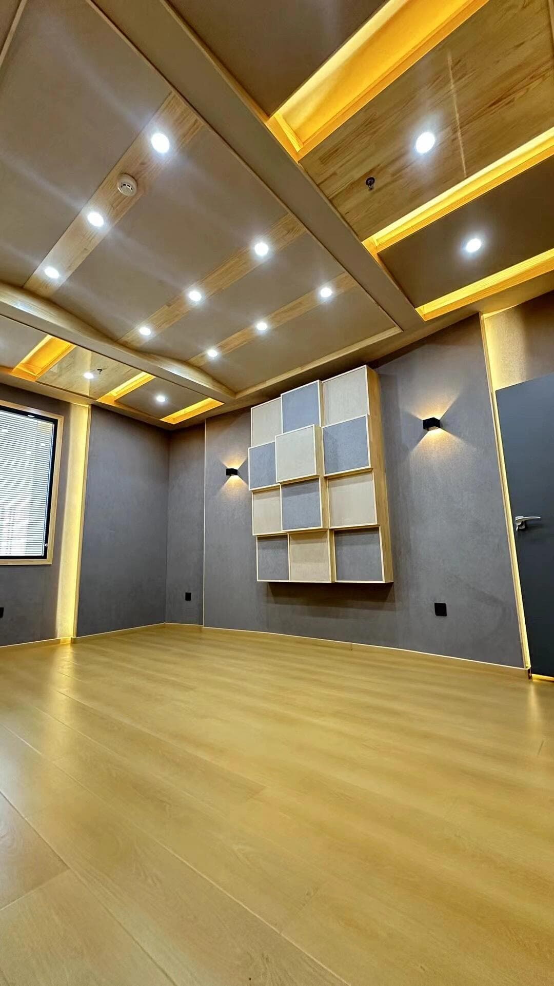 Recording room corner with floating ceiling panels and staggered square acoustic wall modules