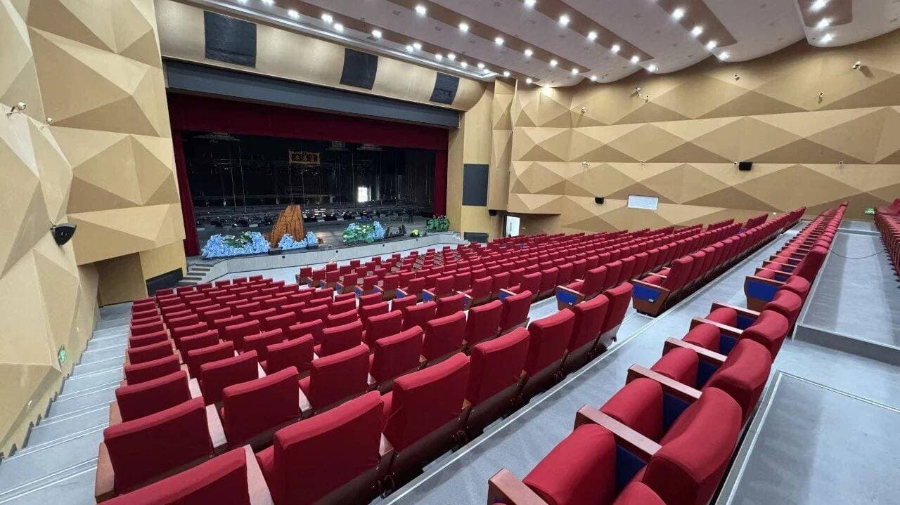 Wide interior view of Shule Performing Arts Center showing seating geometry and stage opening