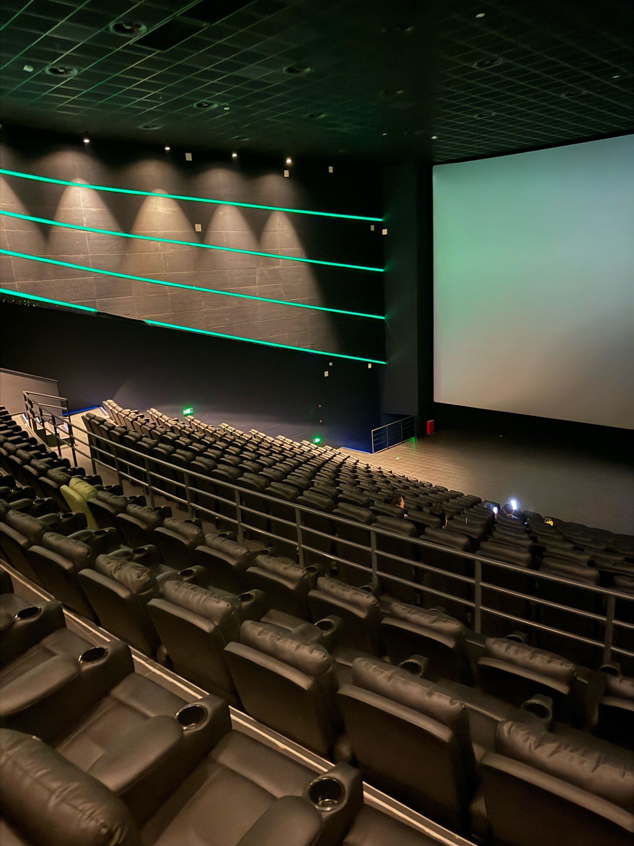 Premium private screening room with leather recliners, star ceiling, and low-glare ambient guidance lighting