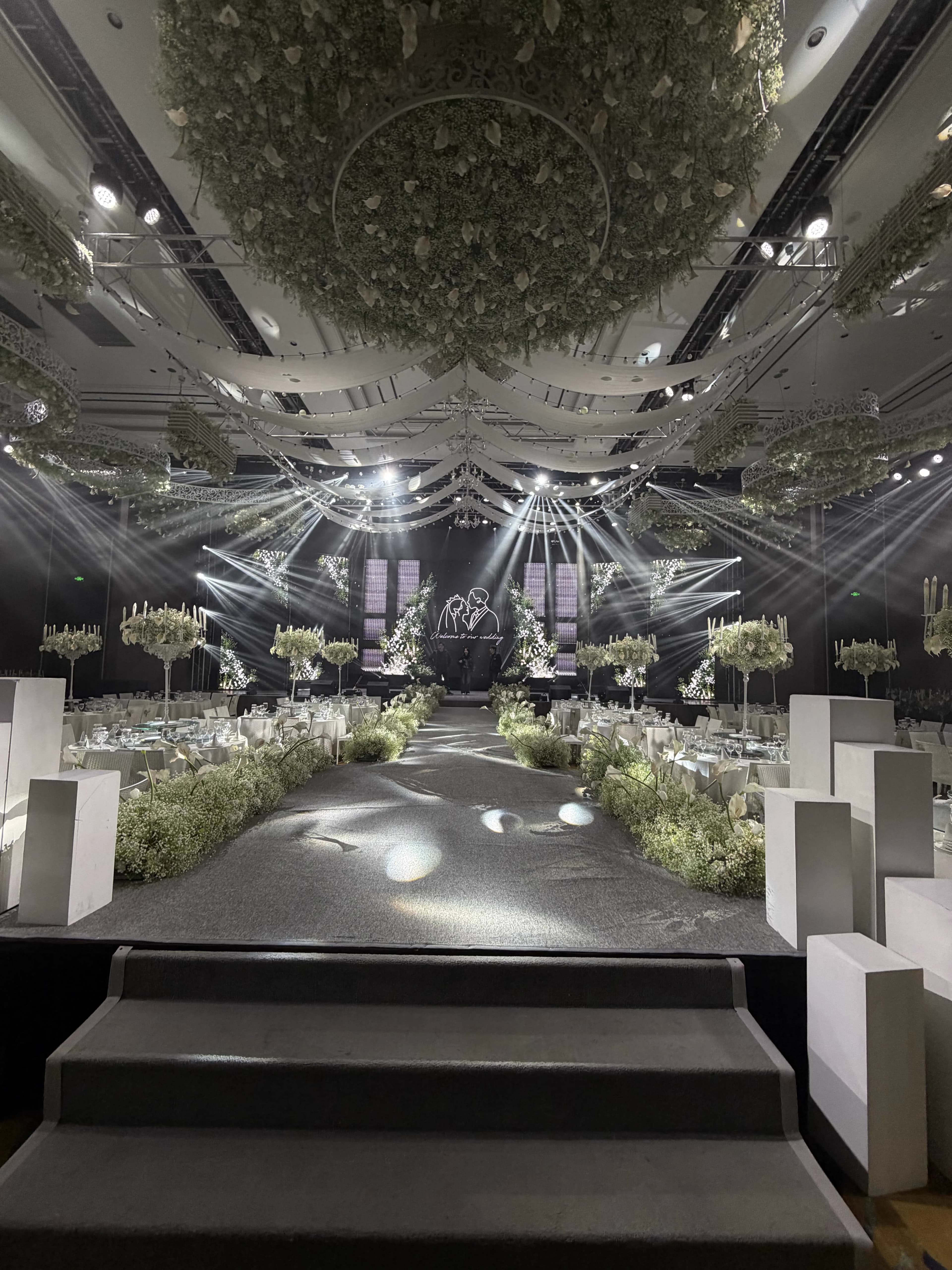 Minimalist pure white ballroom perspective with distributed linear lighting and stage LED anchors
