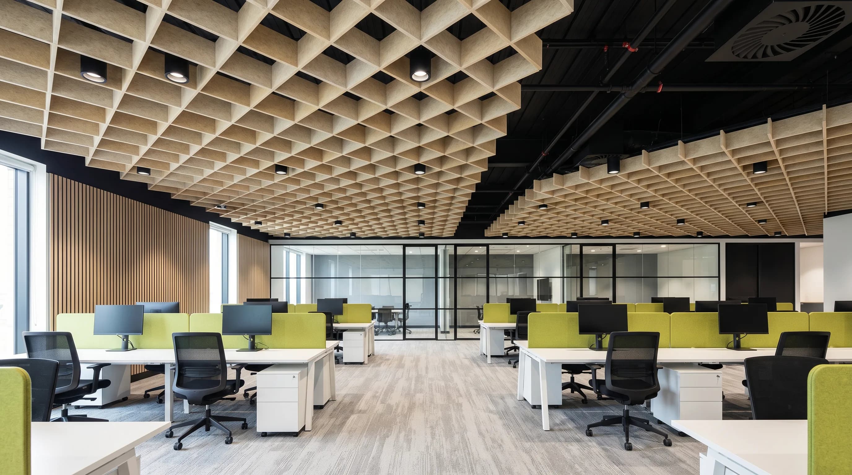 Open-plan office overview showing suspended acoustic elements above workstations