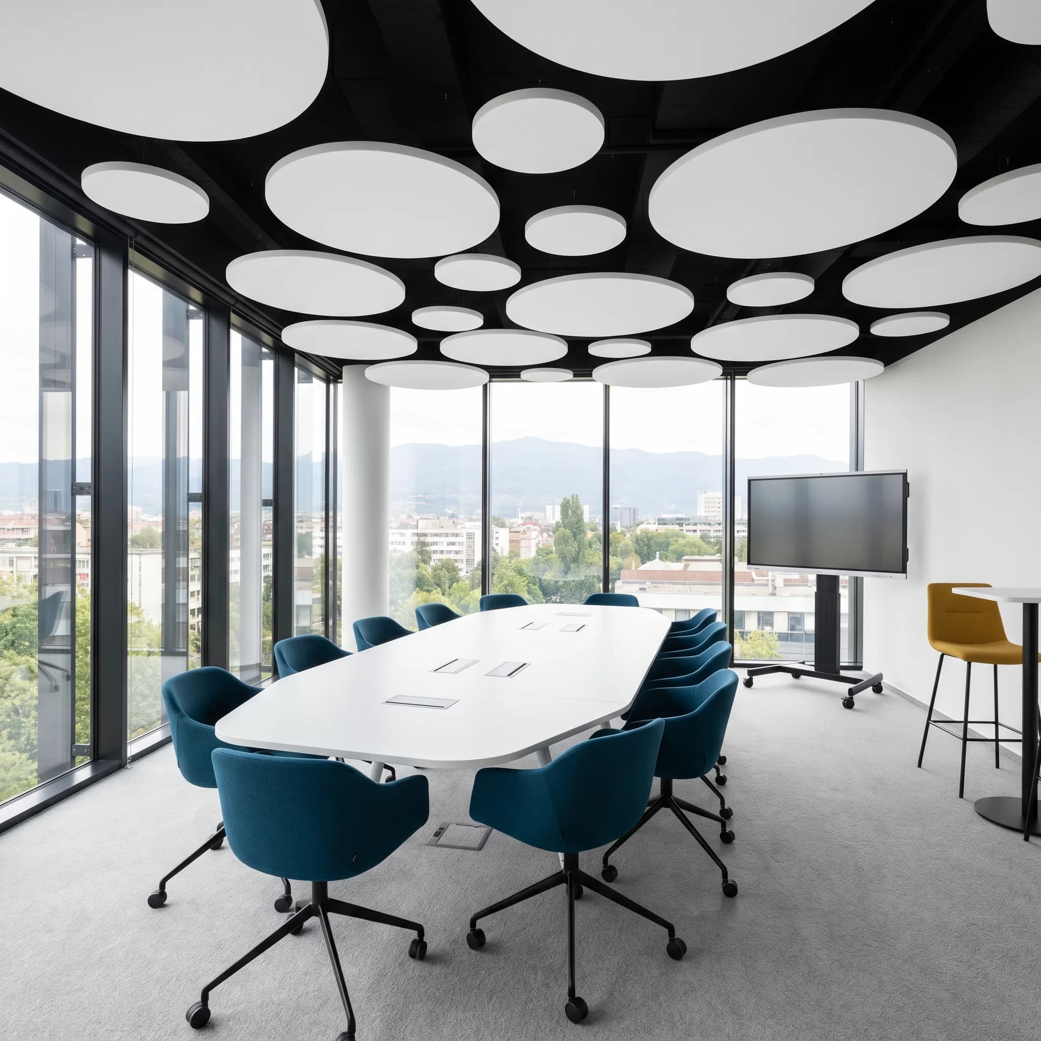 Glass meeting room with suspended acoustic clouds