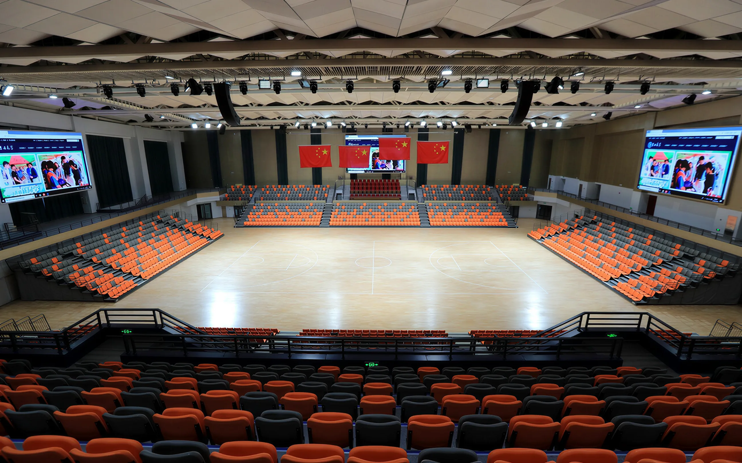 Wide-angle ground-level panoramic view of the arena with origami-style acoustic ceiling matrix and telescopic seating